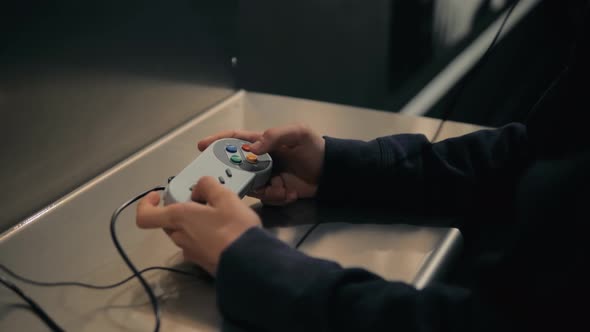 Child Playing a Shooting Genre Video Game Closeup of the Hands Holding the Controller and Pushing