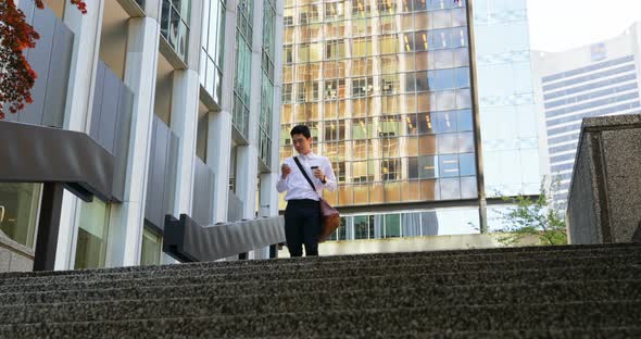 Man using mobile phone and walking down the stairs