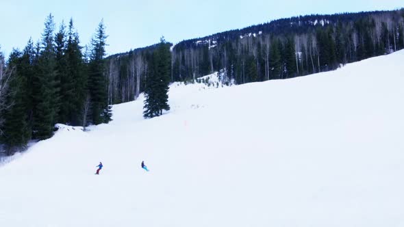 People snowboarding on snowy mountain