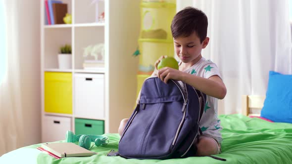 Boy Packing Schoolbag with School Supplies at Home 12