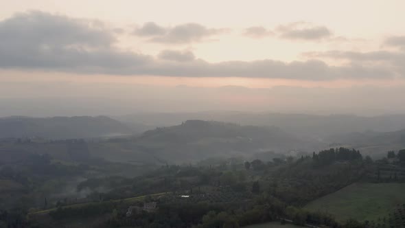 Early Sunny morning. Thick fog over fields, farmhouses and vineyards