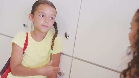 Video of happy diverse girls talking at school lockers