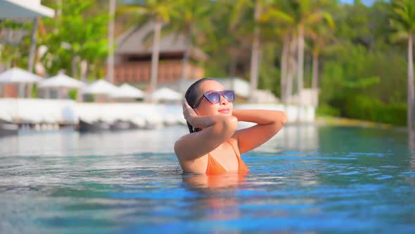 Young asian woman enjoy around outdoor swimming pool for leisure