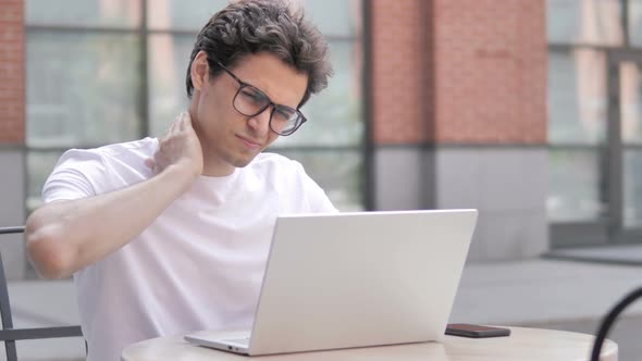 Tired Young Man with Neck Pain Working on Laptop Outdoor