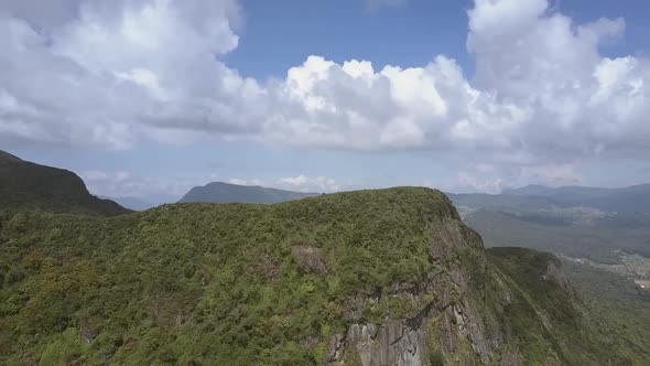 Mountain with Lush Flora Near Small Country Against Sky