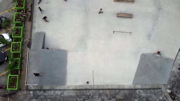 A Teenaged asian Boy Performs with His Skateboard at the Skatepark. Aerial footage