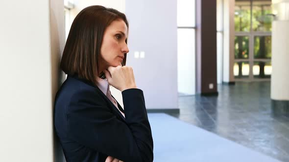 Upset businesswoman leaning against wall 4k