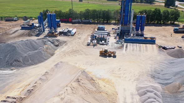 Modern Asphalt Plant Among Piles of Rubble