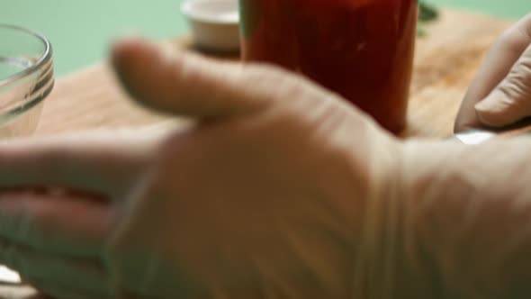 Pouring diced tomatoes from an open can into hand blender glass. Process of making salsa