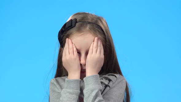 Blonde Girl Is Smiling and Closing Her Face with Palms