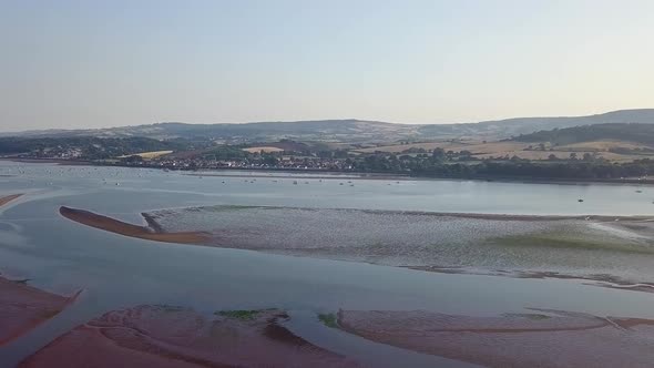 Wide view from the sky of the beach in southwest England, Lympstone. The drone glides downward givin