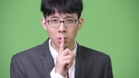 Young Asian Businessman with Finger on Lips