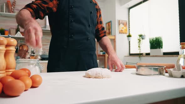 Close Up of Man Sieving Flour on Bread Dough