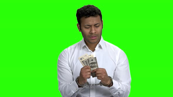 Confused Handcuffed Businessman Holding Money
