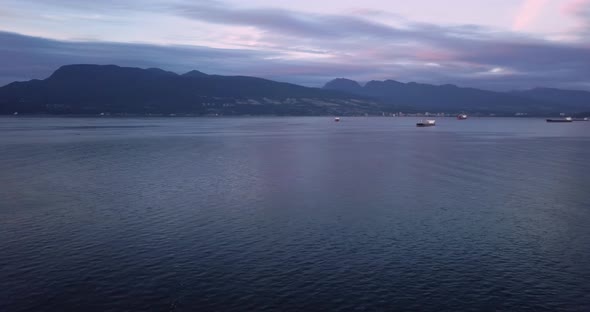 Aerial Sunset Wide Shot Flying Over Pacific Ocean Towards North Shore Panning Right To Reveal Cargo