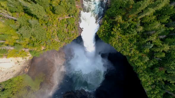 Beautiful water fall through forest cliff on a sunny day 4k