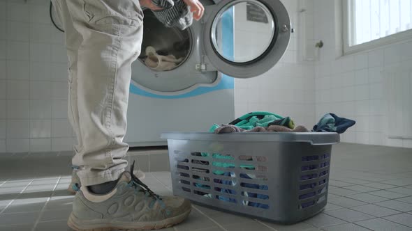 Man loading a washing machine with towels