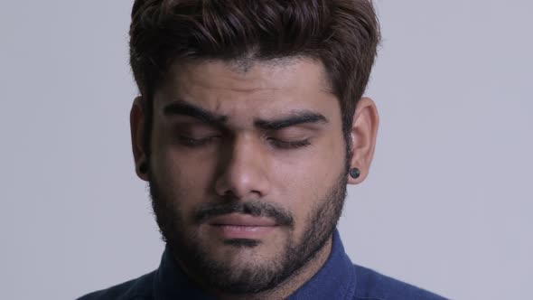 Face of Young Bearded Indian Businessman Looking Sad and Depressed