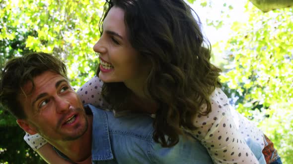 Man giving piggyback to woman in park