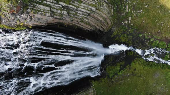 High Waterfall with Fast Water Streams Flows Among Cliffs