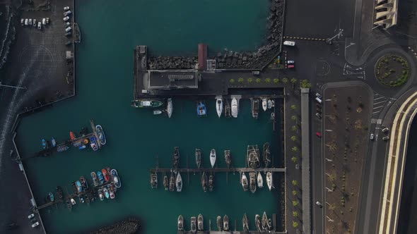 Aerial top-down forward over boats moored at Tazacorte harbor, La Palma. Canary islands