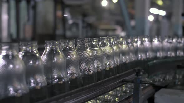 Movement of Finished Products Glass Bottles on the Conveyor Belt at the Glass Factory Workflow at