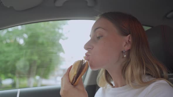 Hungry Woman Eating Burger Sitting in Car, Junk Food