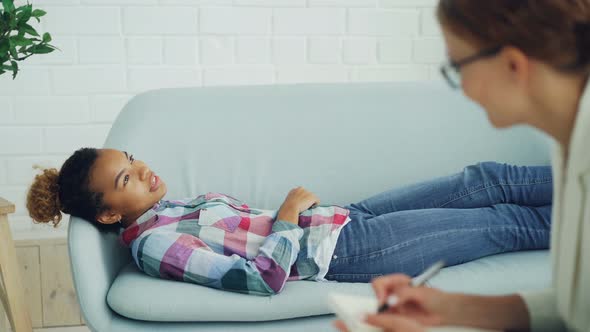 Attentive Psychologist Is Holding Consultation with African American Woman, Listening and Making