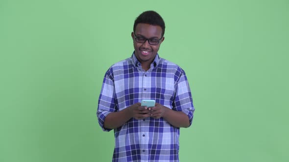 Happy Young African Hipster Man Thinking While Using Phone