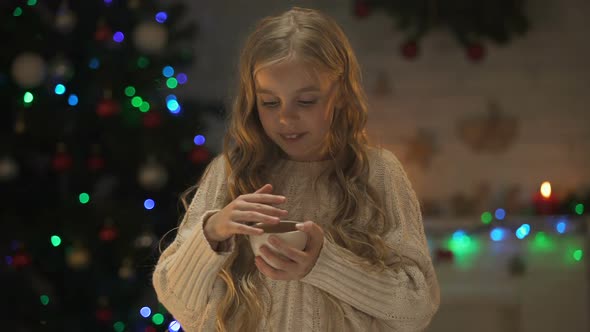 Girl Holding Cup With Hot Chocolate Near Glowing Christmas Lights, Holiday