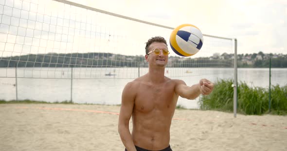 Shirtless Young Man Play with Ball at Voleyball Net