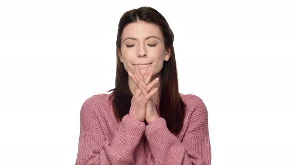 Portrait of Praying Mature Woman in Pink Sweater Putting Hands Together and Begging God for Luck