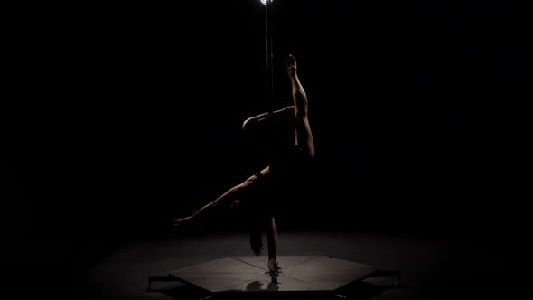 Female Dancer Sexy Poledance . Black Background. Slow Motion. Silhouette