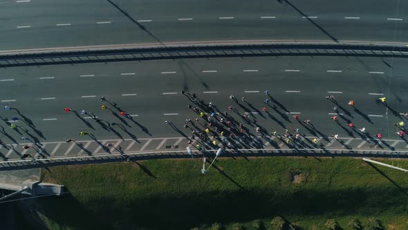 Aerial Drone Fooage. Following Marathon Running On Road Bridge. Top View