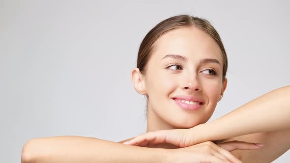 Beautiful Young Woman with Clean Fresh Skin Standing Over Light Grey Background