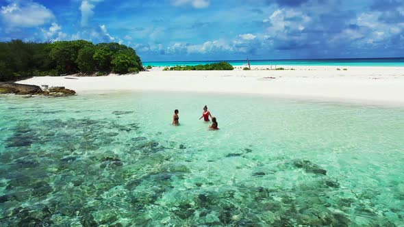 Beautiful ladies happy and smiling on tropical tourist beach wildlife by blue ocean and white sand b