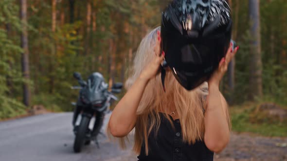 Adult Blonde Woman Motorbike Rider Takes Off Her Helmet and Raises Her Hair