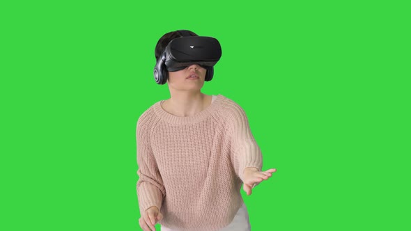 Cute Young Woman Walking and Using Interactive VR Headset on a Green Screen, Chroma Key