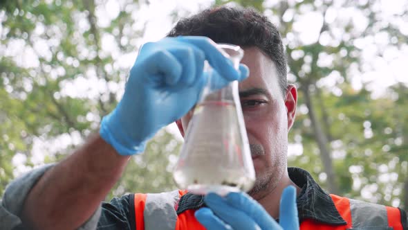 Close up of Biological engineer check contaminants in factory wastewater in a test tube