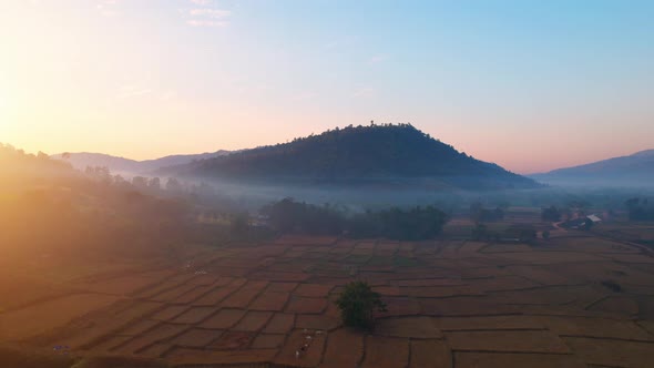 Aerial view from a drone over misty landscape on farmland. 4K