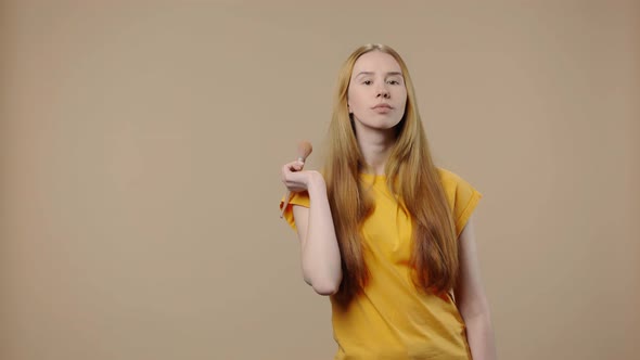 Portrait of a Model with Natural Beauty Corrects Makeup with a Powder Brush