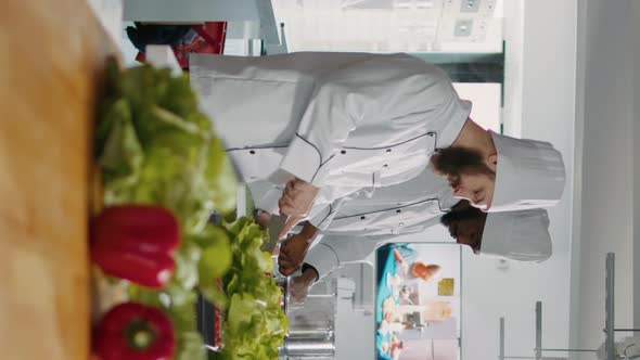 Vertical Video Portrait of Gourmet Cook Slicing Green Salad on Cutting Board