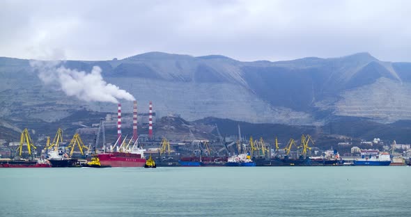 Motorboats and Cargo Vessels Drift in Harbour with Cranes