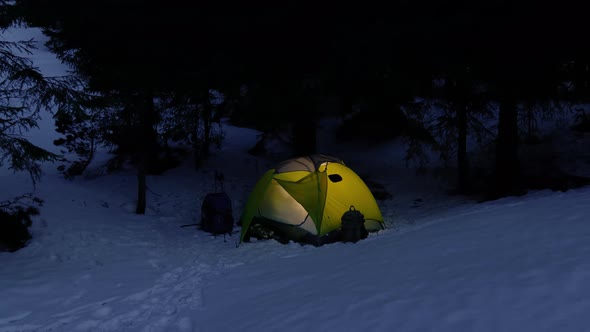 Yellow Iluminated Tent in Winter Forest