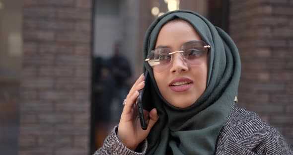 Muslim Woman in Veil Talking By Phone Outdoors