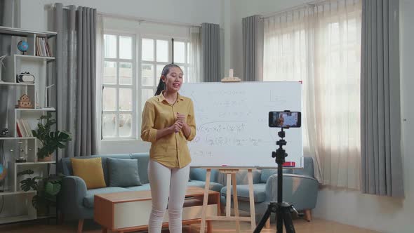 Asian Female Teacher With Marker Pen Shoots Video By Smartphone Camera While Teaching Math At Home