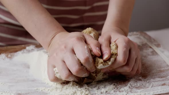 Lady in Apron Kneads Dough for Gingerbread on Wooden Board