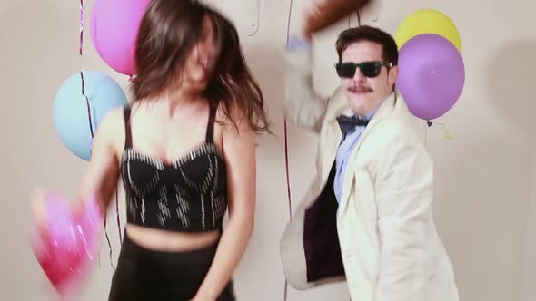 Slow motion of woman and man having awesome time dancing in photo booth