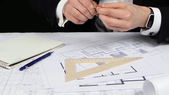 Businessman with a Compass and Ruler Makes Measurements for the Drawing. Close Up