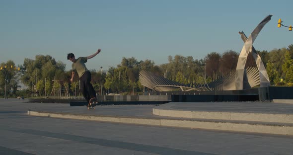Teenage Skateboarder Is Doing Tricks and Jumps at the Park, 